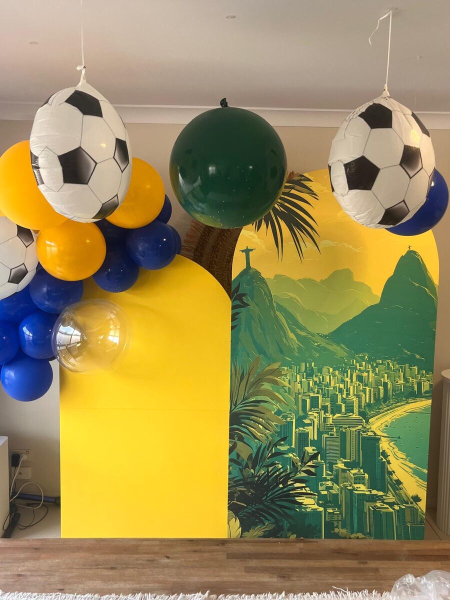 Brazil themed party with yellow backdrop and football balloons